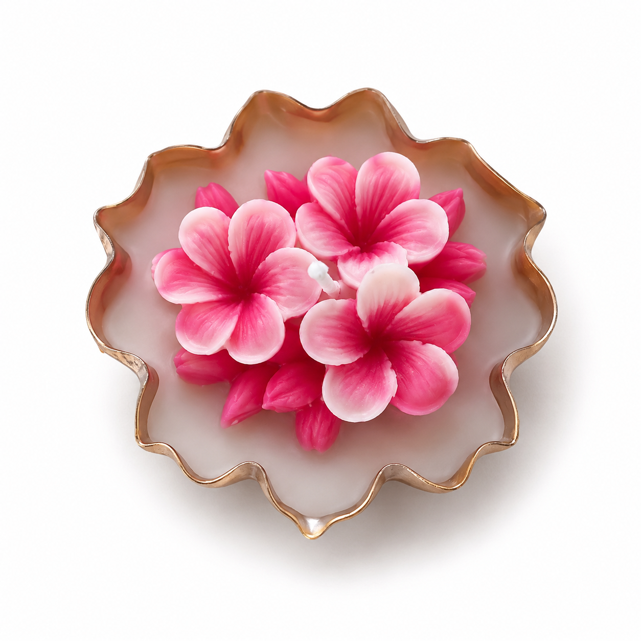 Itrāa Essence floral candle in a decorative urli with vibrant flower designs and a lit wick, creating a warm, aromatic glow.
